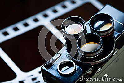 Old retro movie camera on background of perforation film Stock Photo