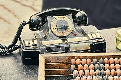 Old retro objects antique phone, accounting abacus on wooden table Stock Photo