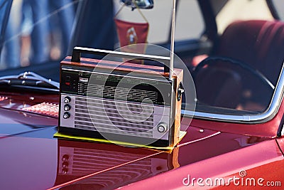 Old retro radio with antenna on a vintage retro car hood Stock Photo