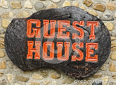 Old retro wood sign with the text Guest house. Stock Photo