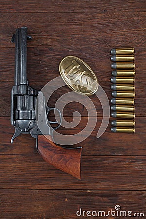 Old revolver with cartridges and U.S. Army soldier& x27;s belt with a buckle Stock Photo