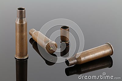 Old rifle and pistol sleeves / bullet casings on a dark mirror background Stock Photo