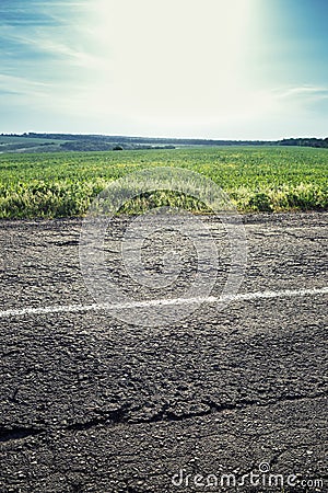 Old road with a dividing strip, grass and sky in the background Stock Photo