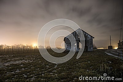 Shot of an old road and shed on a cloudy foggy night Stock Photo