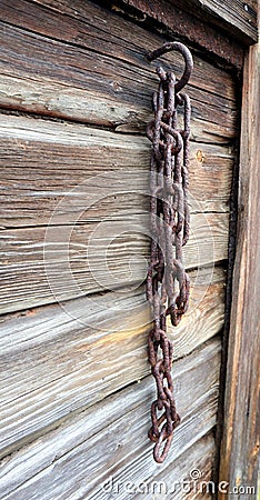 Old rosty chain on a barn wall Stock Photo