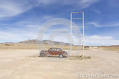 Old rotten vintage car at a patrol station in the desert at Route 895 at Rachel, Alamo, Nevada Stock Photo