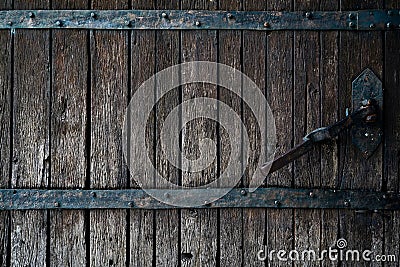 Old rotten wormy ancient oak door and metal parts, wooden textured castle door Stock Photo