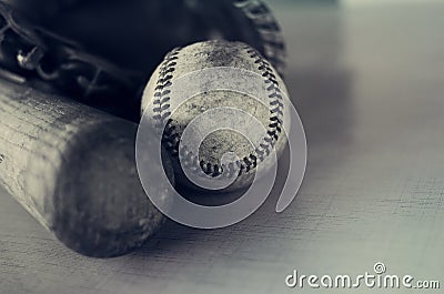 Old rough and rugged baseball and vintage wooden bat on blue texture background. Stock Photo