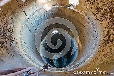 Old ruined concrete tube of abandoned dryer for grain. Vertical tubing shaft, view from above Stock Photo