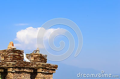 Old ruined Grit stone stone wall background against blue sky with cotton wool clouds and Kanchenjunga mountain range. Rabdentse Stock Photo