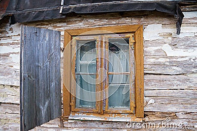 An old ruined wooden house in the village. Details of the facade of a historic wooden house with carved shutters and vintage decor Stock Photo