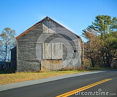 Old Rural Remote Aged Vintage Wooden Warehouse Building along the Street. Barn, Farmhouse, Garage, Storage, Granary, Logistics, Stock Photo