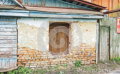Old Russian brick house in dilapidated condition with boarded-up window Stock Photo