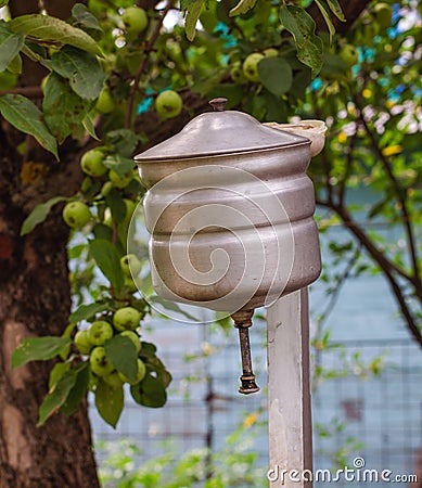 An old russian metal washstand in summer apple garden Stock Photo