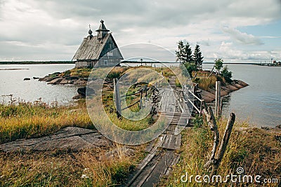 Old russian Orthodox wooden church in the village Rabocheostrovsk, Karelia. Abandoned church on the coastline. Stock Photo