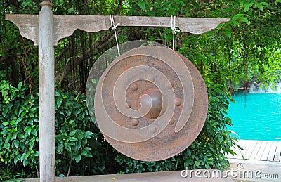 Old rusted gong - Traditional ancient instrument hanging in the midst of nature Stock Photo