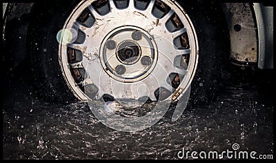 Old rusted wheel and tire from an old car getting inundated by f Stock Photo