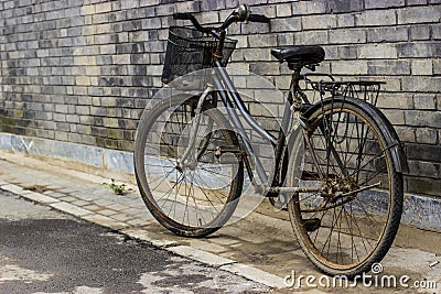 Old Rustic Bicycle Leaning Against a Brick Wall Stock Photo