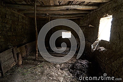Old rustic clay cowshed interior with window Stock Photo