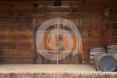 Old rustic wooden double door with wine barrels Stock Photo