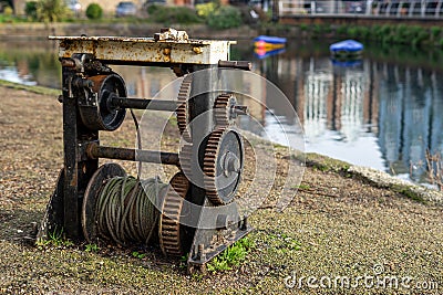 An old rusty Barge winch next to a canal used as part of an old canal lock Stock Photo