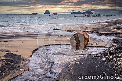 Old rusty barrel oil on beach in Asia on sunset Stock Photo