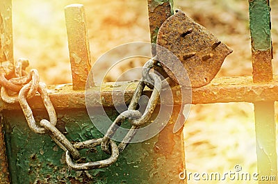 Old rusty broken lock on a green gate. Summer, sunny day. Stock Photo