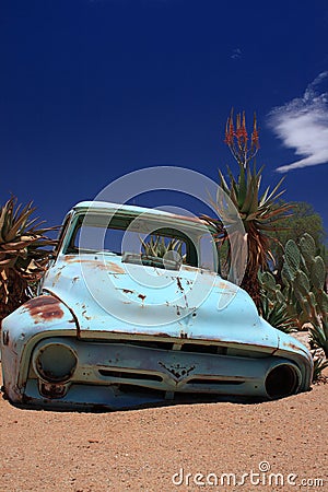 Old rusty car wreck stranded in desert