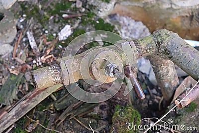old rusty crooked water pipe with faucet Stock Photo