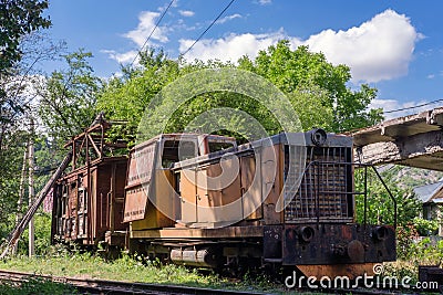 Old rusty diesel locomotive with broken wooden cargo wagon Stock Photo