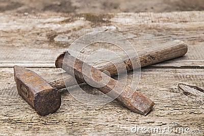 old hammer and rusty chisel on a wooden unpainted workbench Stock Photo