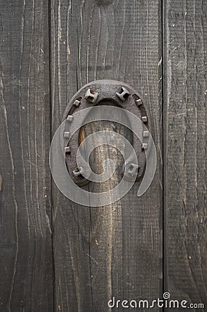 Old rusty horseshoe nailed to a front wooden door close Stock Photo
