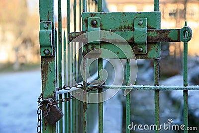 Old rusty iron gate with locking bar and padlock with chain Stock Photo