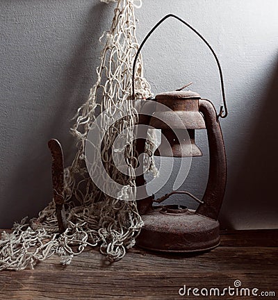 Old rusty kerosene lamp, knife and fishing Net Stock Photo