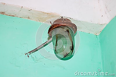 Old rusty lamp on a green wall Stock Photo