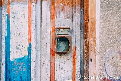 Old rusty mailbox on colour wooden door. Peeling paint door. Vintage rusty postbox or letterbox concept. Copy space. Stock Photo