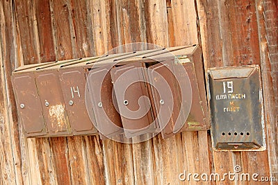 Old rusty mailbox on a wooden fence Stock Photo