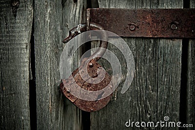 Old rusty opened lock without key. Vintage wooden door, close up concept photo Stock Photo