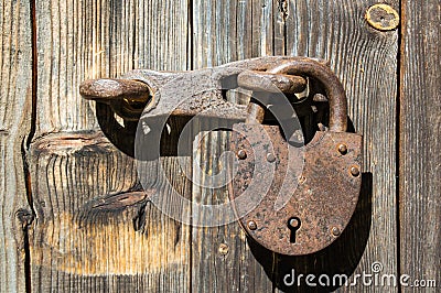 Old rusty padlock on wood brown door Stock Photo