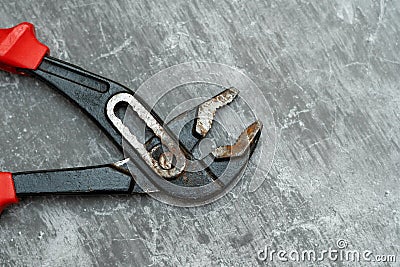 Old and rusty plumbing pliers on concrete floor Stock Photo