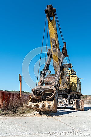 an old rusty quarry excavator is located on the territory of a mining quarry. an open method of mining Stock Photo