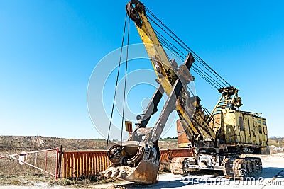 an old rusty quarry excavator is located on the territory of a mining quarry. an open method of mining Stock Photo