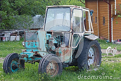 Old rusty soviet-made tractor in the farmyard Stock Photo