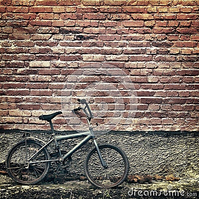 Old rusty vintage bicycle leaning against a brick wall Stock Photo