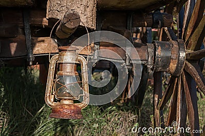 Old rusty vintage oil lantern lamp hanging on a log Stock Photo