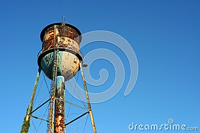 Old rusty watertower against blue sky Stock Photo