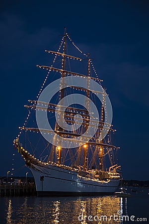 Old Sailing Ship Lit up in Midnight Blue Sky Stock Photo