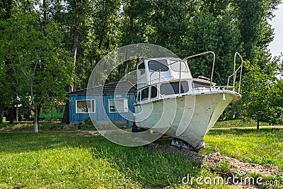 Old sailing yacht on land. Old white motor yacht beached at a do Stock Photo