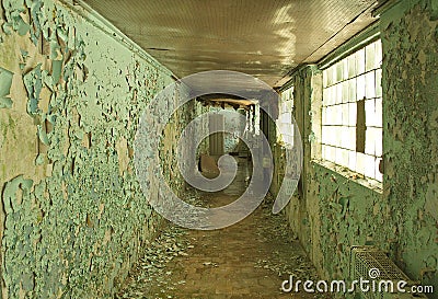 Old, scary hallway with green cracked paint, radiators and windows. Forgotten, abandoned ghost town Skrunda, Latvia. Stock Photo