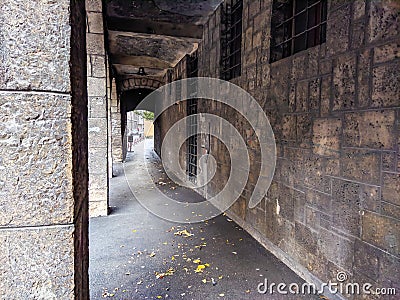 Old and scary looking exterior hallway corridor next to an old building facade with dark and abandoned feeling to it Stock Photo